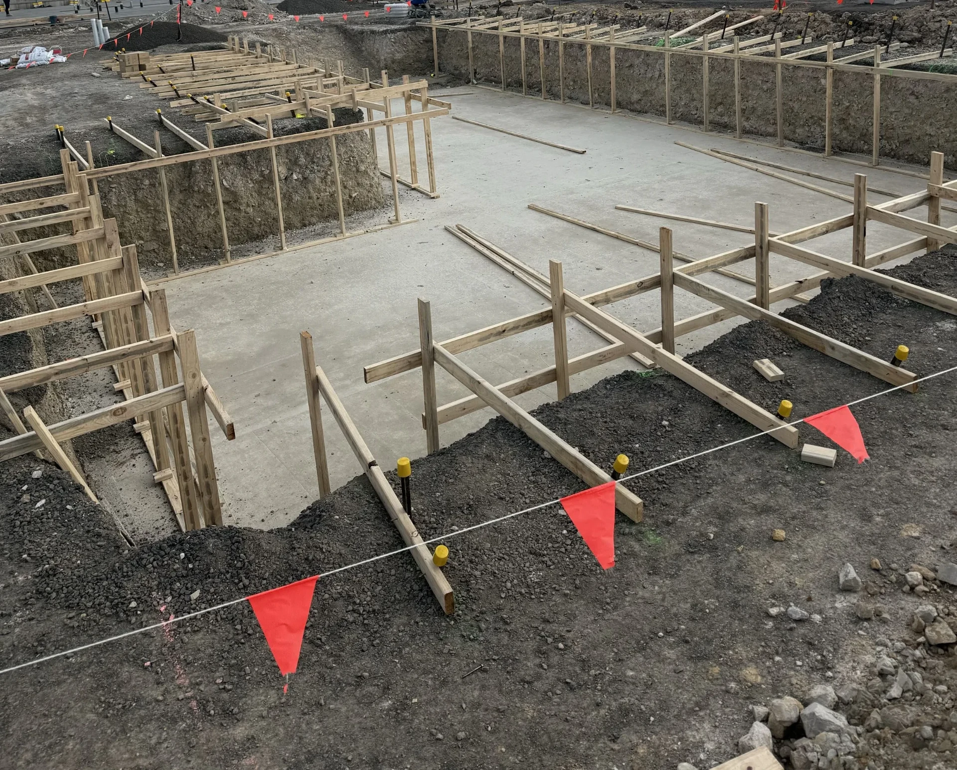 Wide view of a large Beveridge clubhouse pool footprint with concrete base and perimeter formwork.